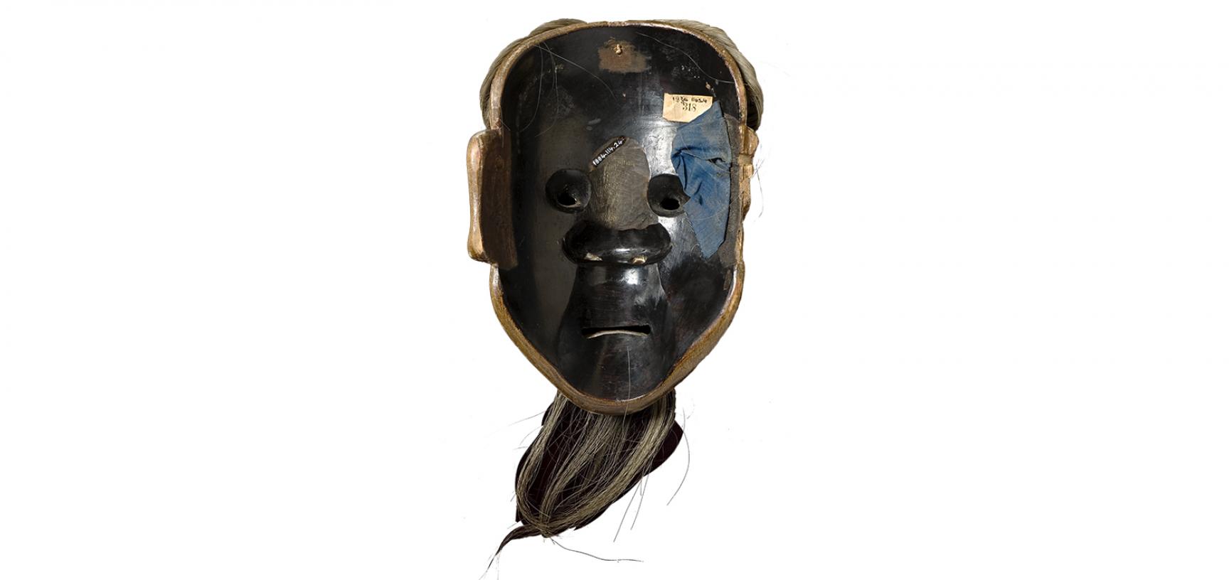 Reverse of mask (1184.112.24) after conservation - the back of the mask reveals additional carving to the bridge of the nose and textile padding on the cheek
