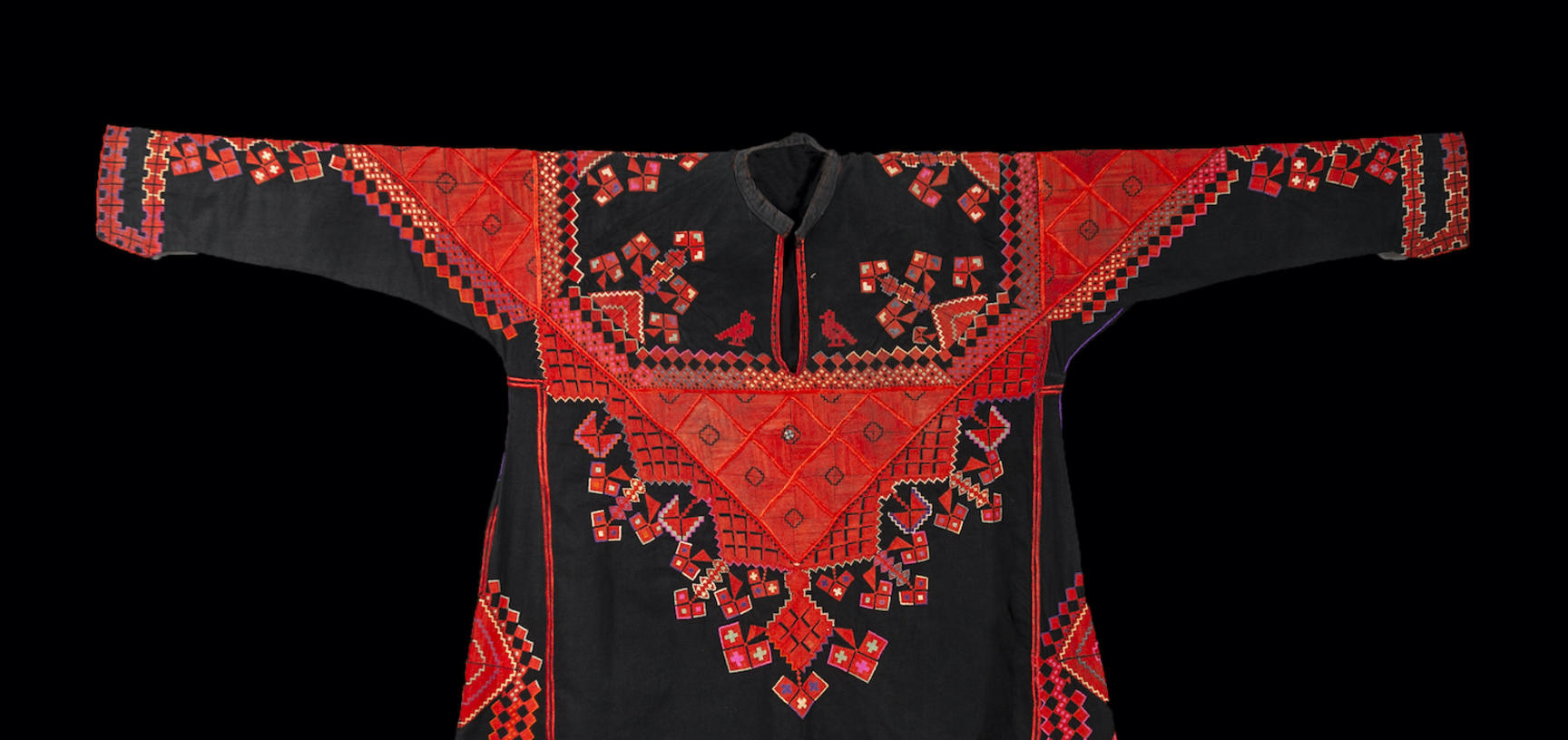 A dark long sleeve dress decorated with red embroidery.  