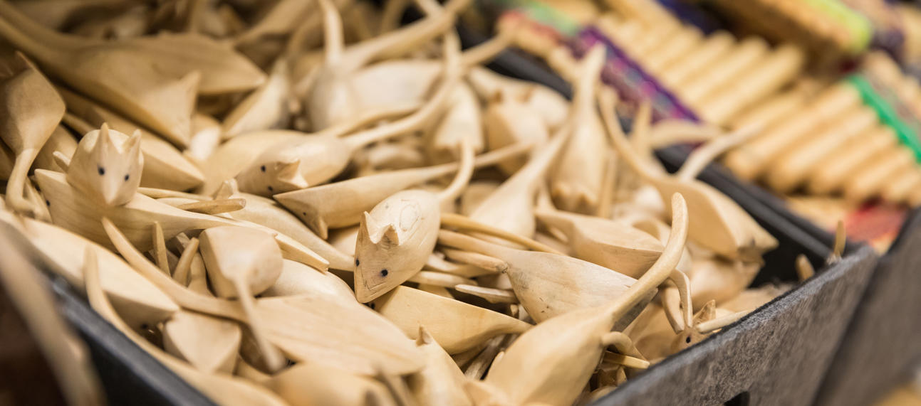 Small carved wooden mice in grey felt basket in shop