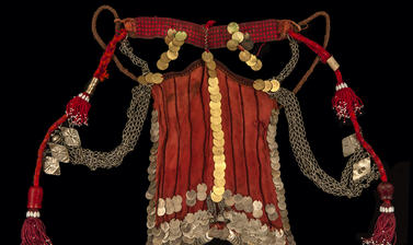 An orange face veil decorated with coins   