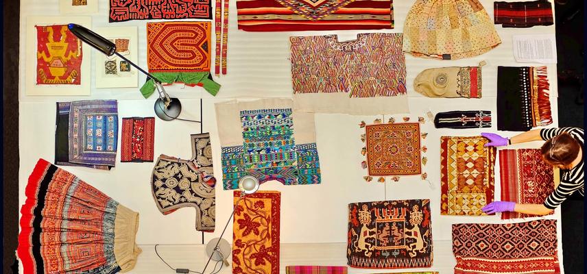 View from above of colourful textiles being laid out on table