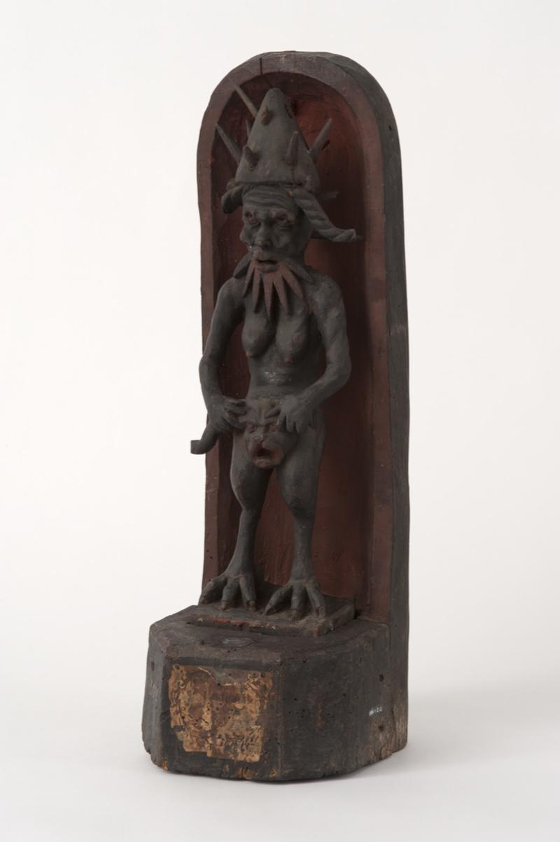 Small statue of a human-type figure with a beard, breasts, bird-like legs.