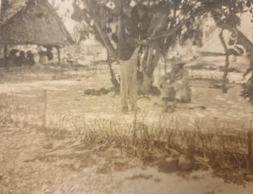 Blurry black and white photo of man seated on ground being mesmerised by a standing man