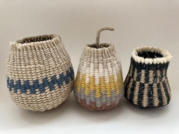 Three patterned baskets with a stem sticking out of the middle one