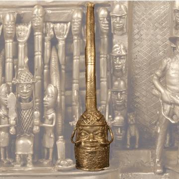 A bronze head with a bronze tusk mounted upon it